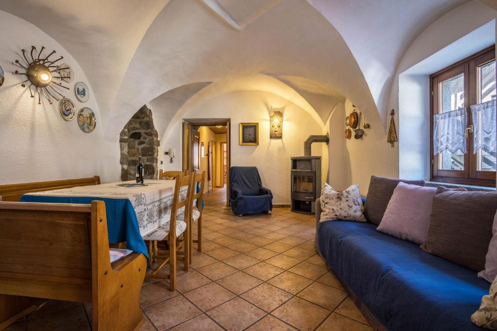 a living room with a blue couch and a table at Appartamento Jasmine in Molina di Ledro