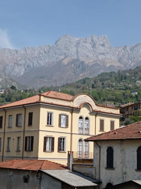duży budynek z górami w tle w obiekcie Casa Mirta w mieście Mandello del Lario