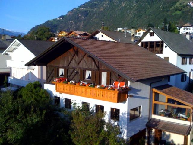 Casa bianca con tetto marrone e balcone. di Ferienwohnungen Schweitzer a Parcines