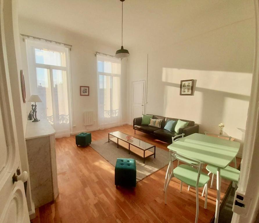 uma sala de estar com um sofá e uma mesa em Spacieux et lumineux appartement vue mer Joliette em Marselha