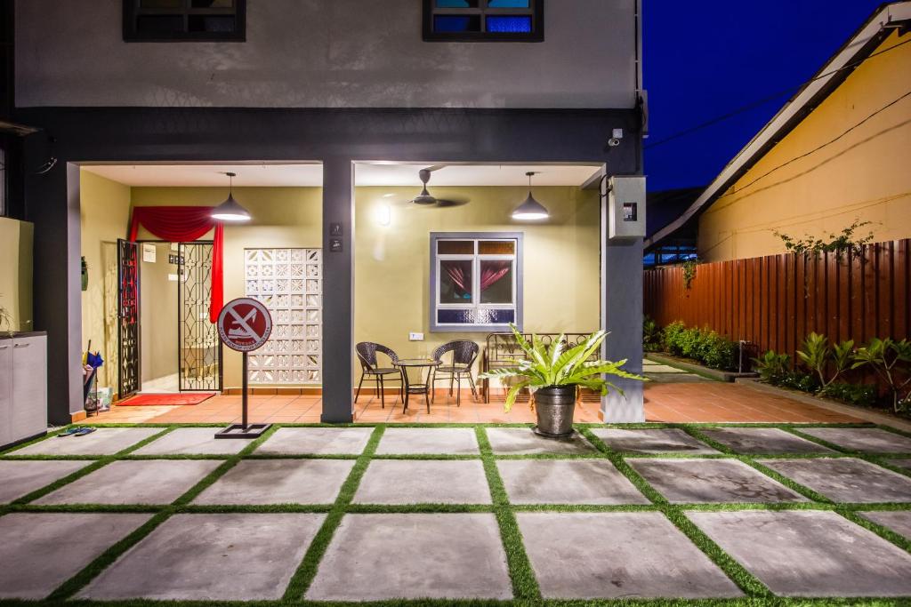 a home patio with a table and chairs at Explore 5BR Gardenhouse Retreats (Free Parking) in Butterworth