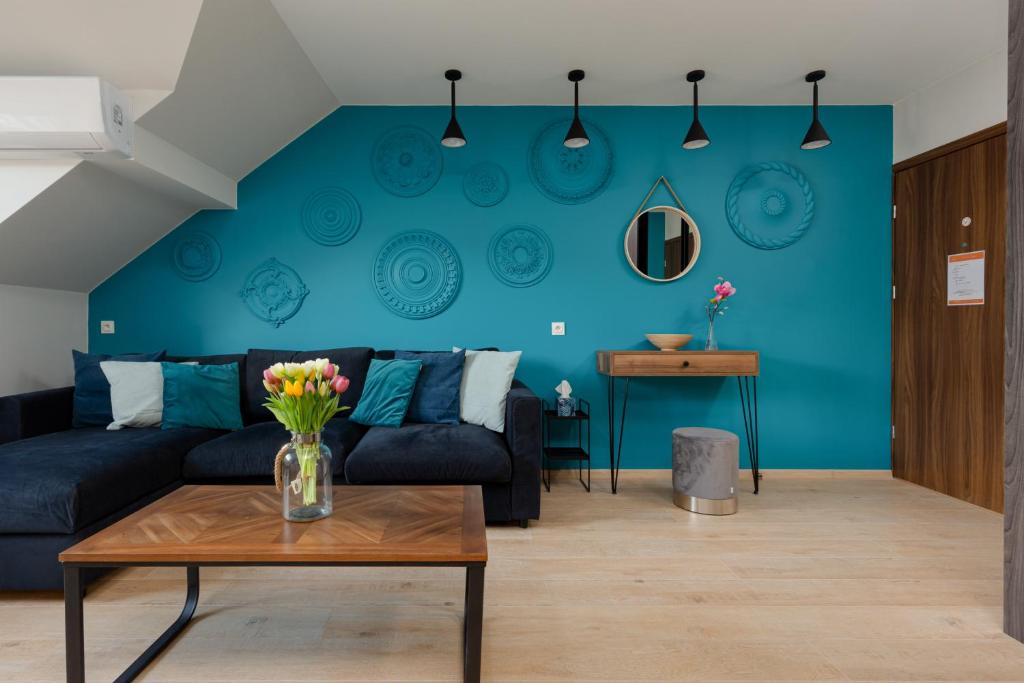 a living room with a couch and a blue wall at Apartaments Port Darłówko by Renters in Darłowo