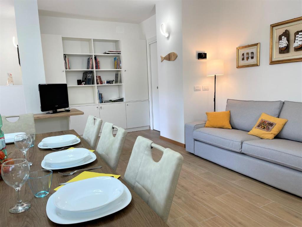 sala de estar con mesa y sofá en GIORNI FELICI: appartamento tutto nuovo, giardino, parcheggio, en Verbania