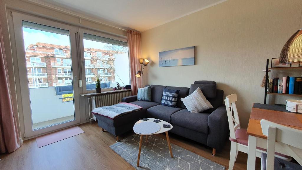 a living room with a couch and a large window at NordseeGlück in Cuxhaven