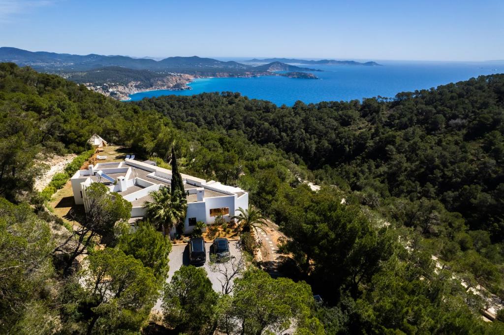 uma vista aérea de uma casa numa colina com o oceano em Villa El Mirador Uno em Es Cubells