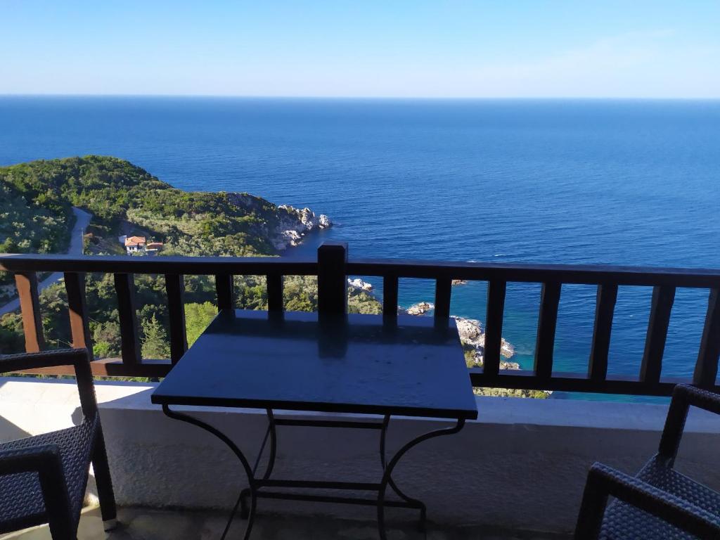 a table on a balcony with a view of the ocean at Triple studio apartment in Mylopotamos Beach in Tsagarada