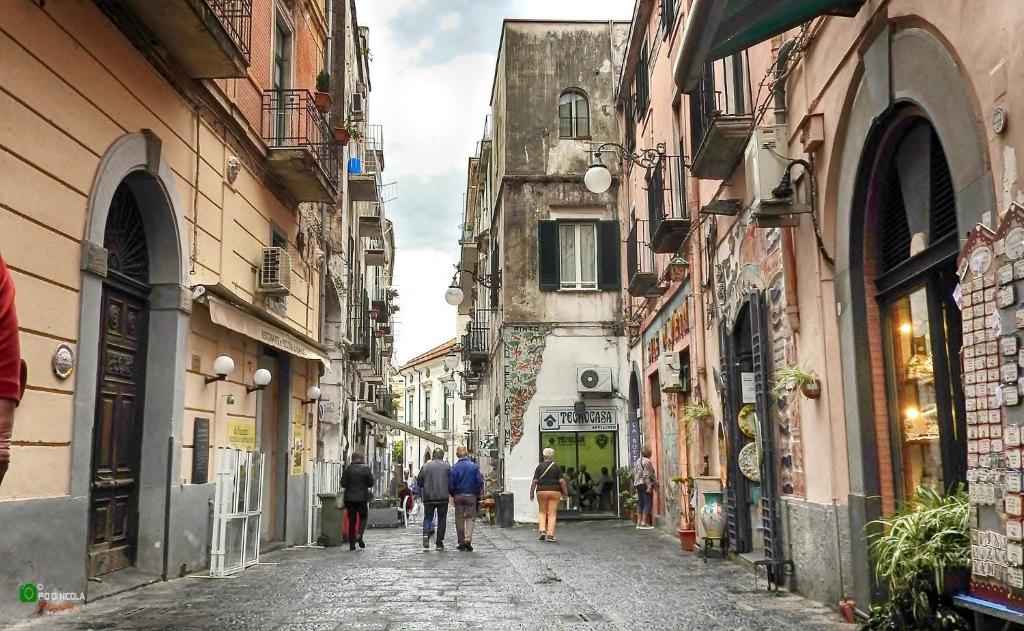 grupa ludzi idących ulicą między budynkami w obiekcie Casa Colombo w mieście Vietri sul Mare