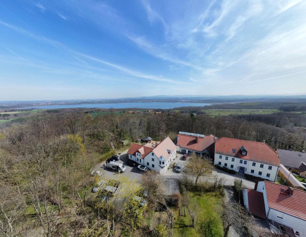 an aerial view of a house with a lake in the background at Hotel Kreuzbergbaude beim Berzdorfer See in Görlitz