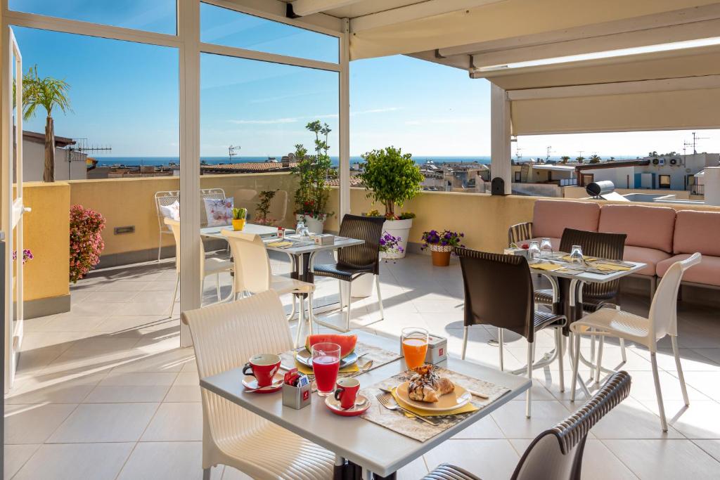 un ristorante con tavoli e sedie sul tetto di un edificio di B&B A casa di Aurora rooms a San Vito lo Capo