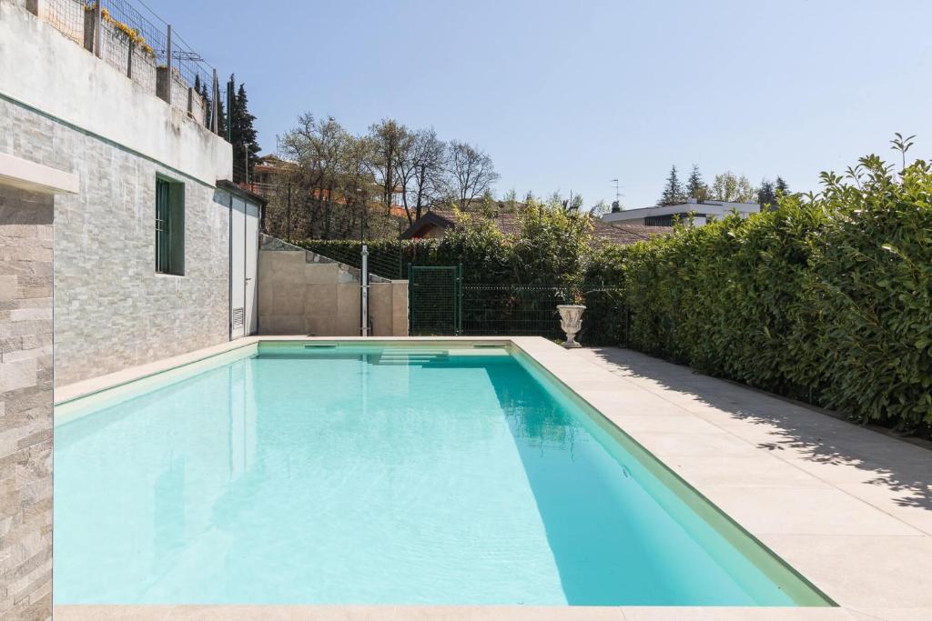 une grande piscine bleue dans une arrière-cour dans l'établissement Villa Gioia, à Padenghe sul Garda