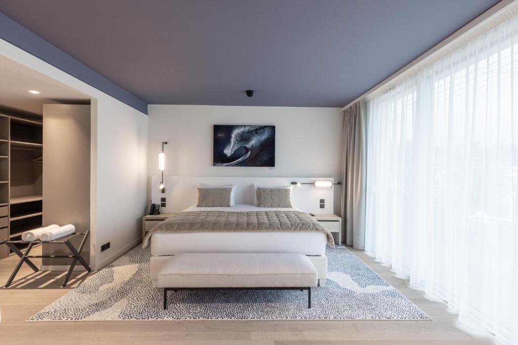 a bedroom with a bed and a large window at Hotel Indigo Cagnes-sur-Mer by IHG in Cagnes-sur-Mer