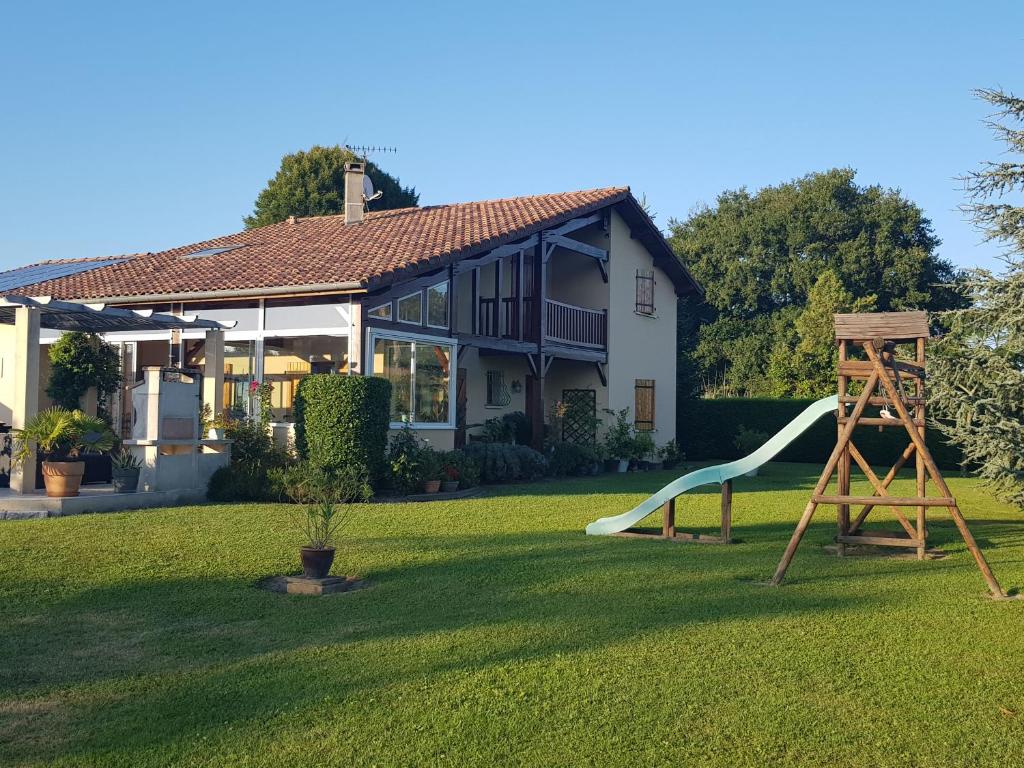 una casa con un tobogán y un parque infantil en Grande maison familiale, en Serres-Gaston