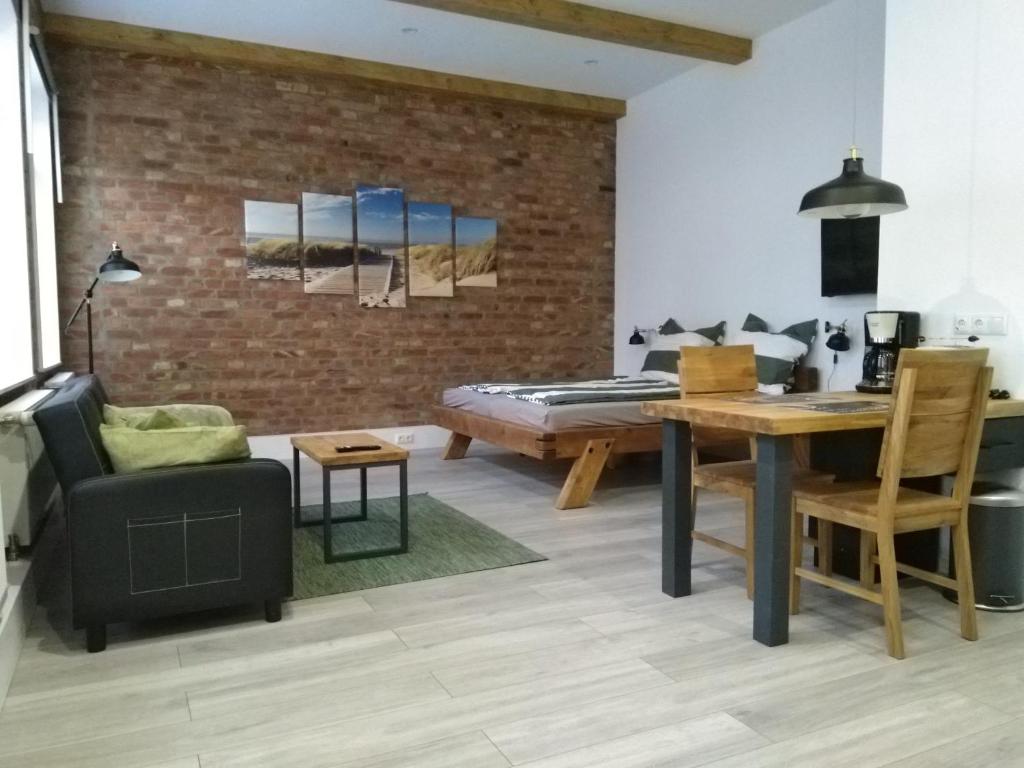 uma sala de estar com uma mesa e uma parede de tijolos em Ferienwohnungen Ribnitz-Damgarten (FR) em Ribnitz-Damgarten