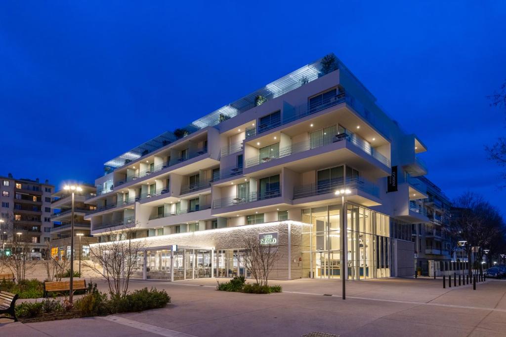 um grande edifício à noite com luzes em Hotel Indigo Cagnes-sur-Mer, an IHG Hotel em Cagnes-sur-Mer