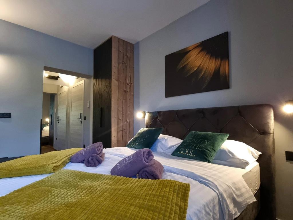 a bedroom with two beds with purple and green pillows at Solemar Luxury Rooms in Zadar