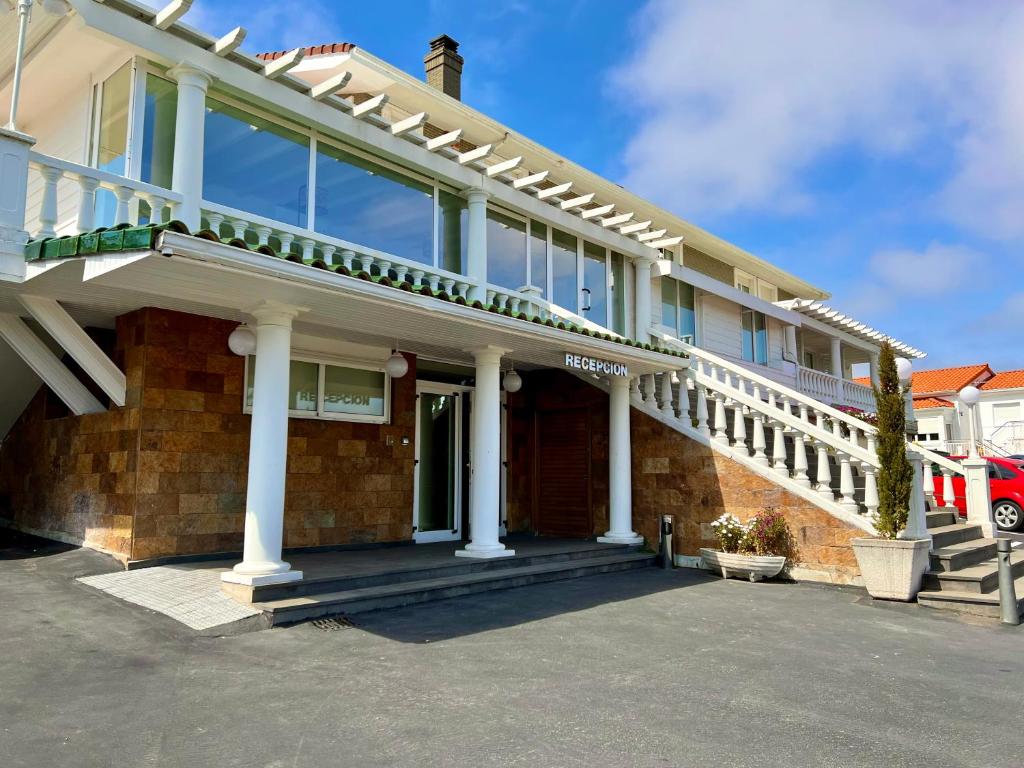 a house with white columns and a staircase on it at Hotel Don Diego in Suances