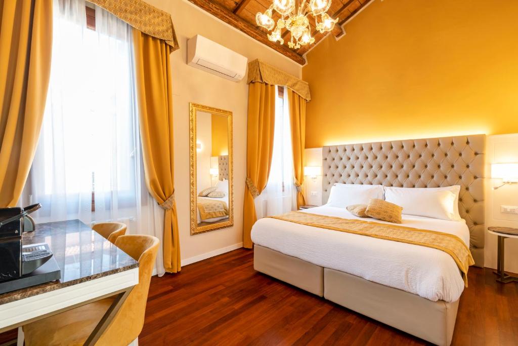 um quarto com uma cama grande e um lustre em Residenza La Duchessa Deluxe Rooms em Veneza