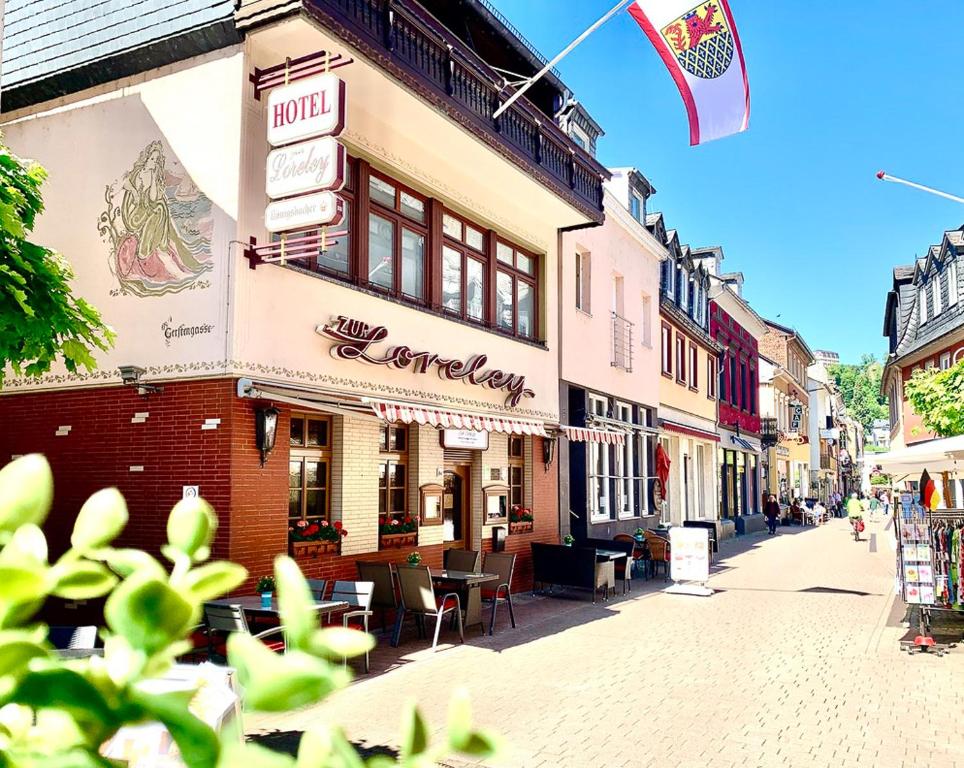 a building on a street with a flag on it at Hotel zur Loreley - Garni in Sankt Goar