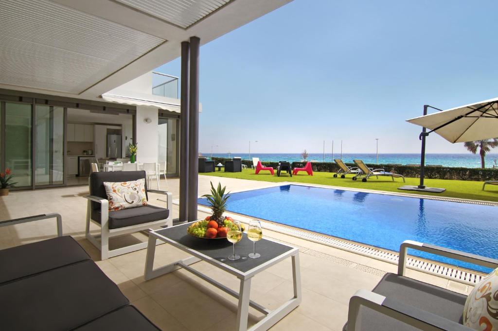 a living room with a pool and a table with fruit on it at Villa Napa Seaside in Ayia Napa