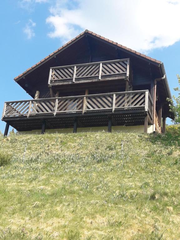 a building on top of a grassy hill at chalet La Vallée in La Bresse