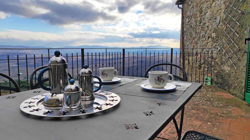 a table with tea pots and cups on a balcony at Ermione in Castiglione dʼOrcia