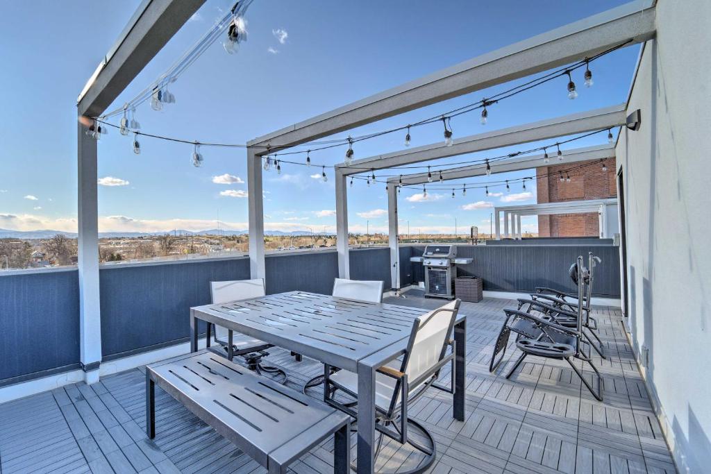a patio with a table and chairs on a deck at Sleek Townhome with Rooftop Patio and Mountain Views! in Denver