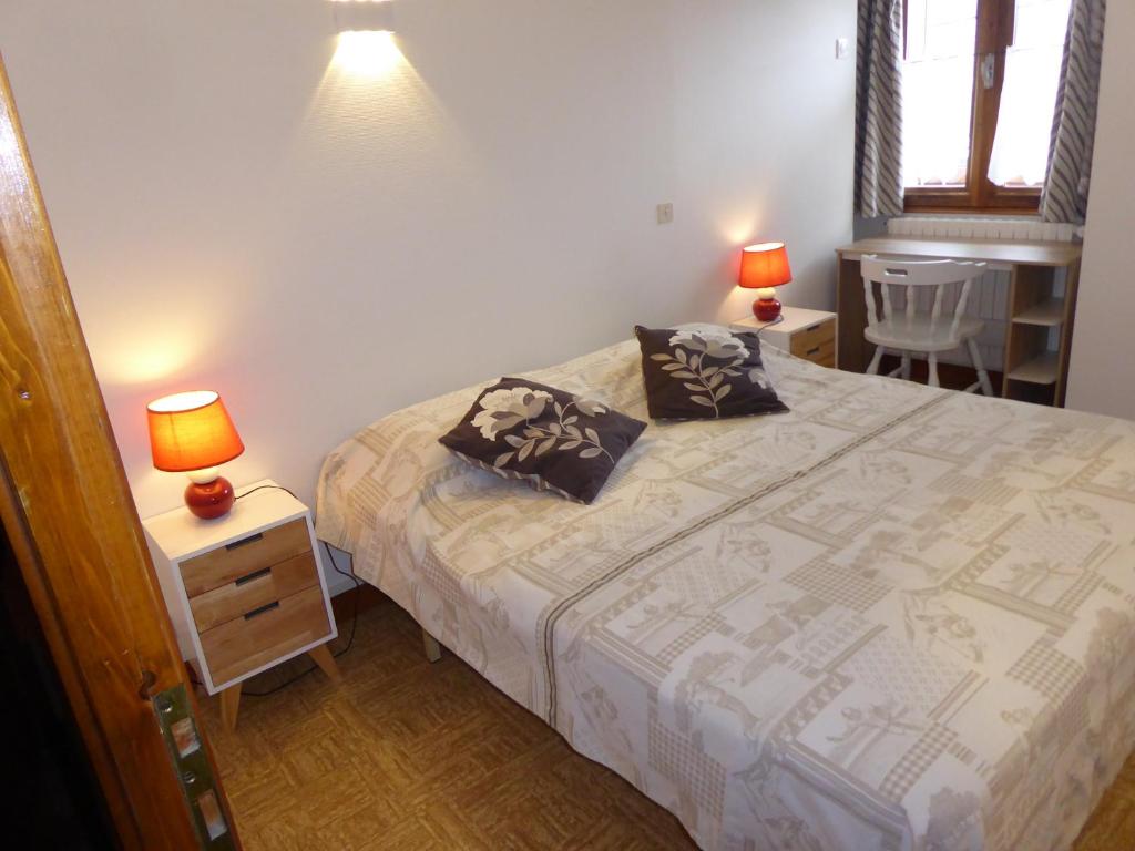 a bedroom with a bed and two lamps on tables at Appartement REINE DES PRES in Megève