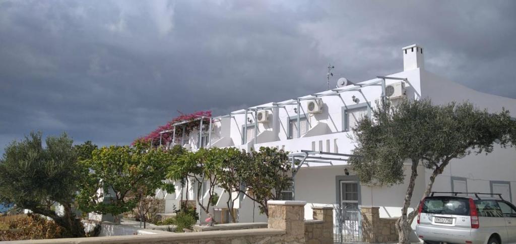 Studios Nina في أموبي: مبنى أبيض فيه سيارة متوقفة أمامه