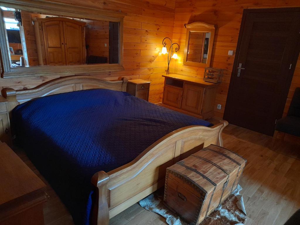 a bedroom with a large bed in a log cabin at Pienińska Hawira in Kluszkowce
