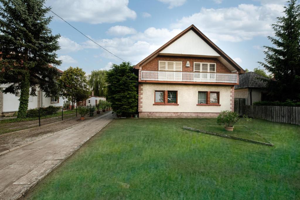 uma casa com um grande relvado em frente em Vadkacsa apartmanház medencével em Zamárdi