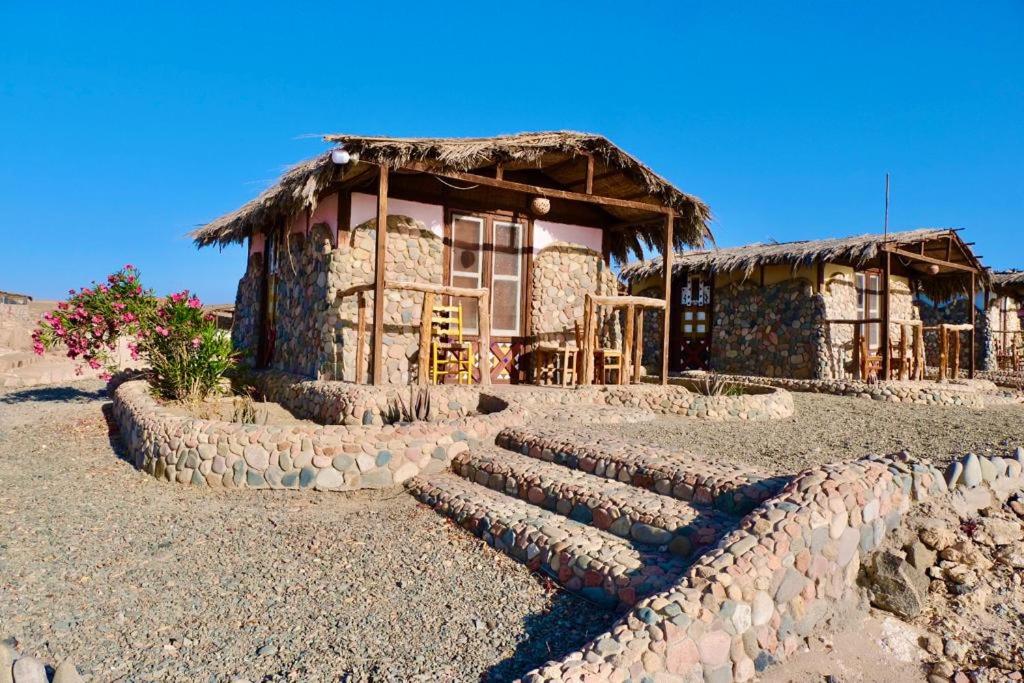 une maison en pierre avec un escalier en pierre en face de celle-ci dans l'établissement Bedouin Valley Eco Resort, à Marsa Alam