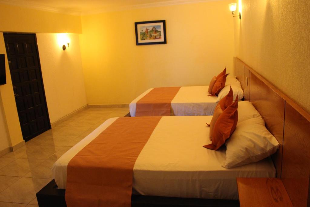 克雷塔羅的住宿－Hotel Boutique Rosa de Lima，一间酒店客房,房间内设有两张床