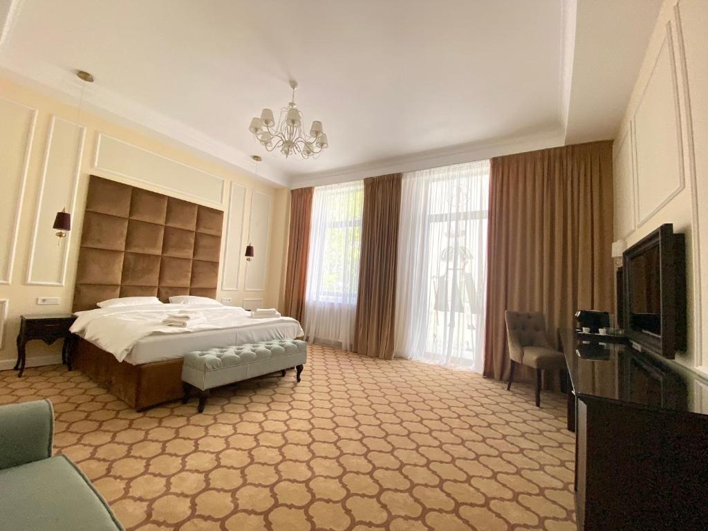 - une grande chambre avec un lit et une télévision dans l'établissement Venetian Bucharest, à Bucarest