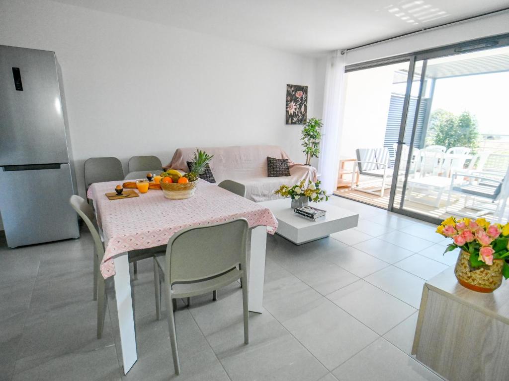 uma cozinha e sala de estar com uma mesa com frutas em Les Vallons du Fort - Terrasse - Wifi - Clim em Porticcio
