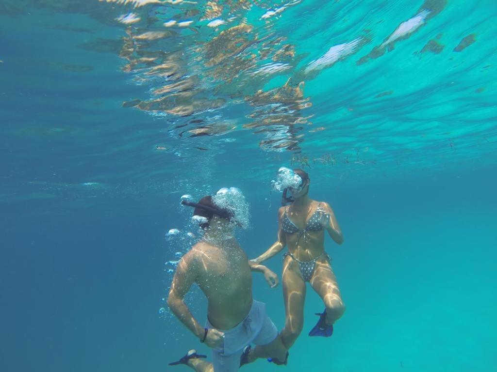 zwei Menschen schwimmen im Wasser des Ozeans in der Unterkunft Coral Castle - Goidhoo Maldives in Baa-Atoll