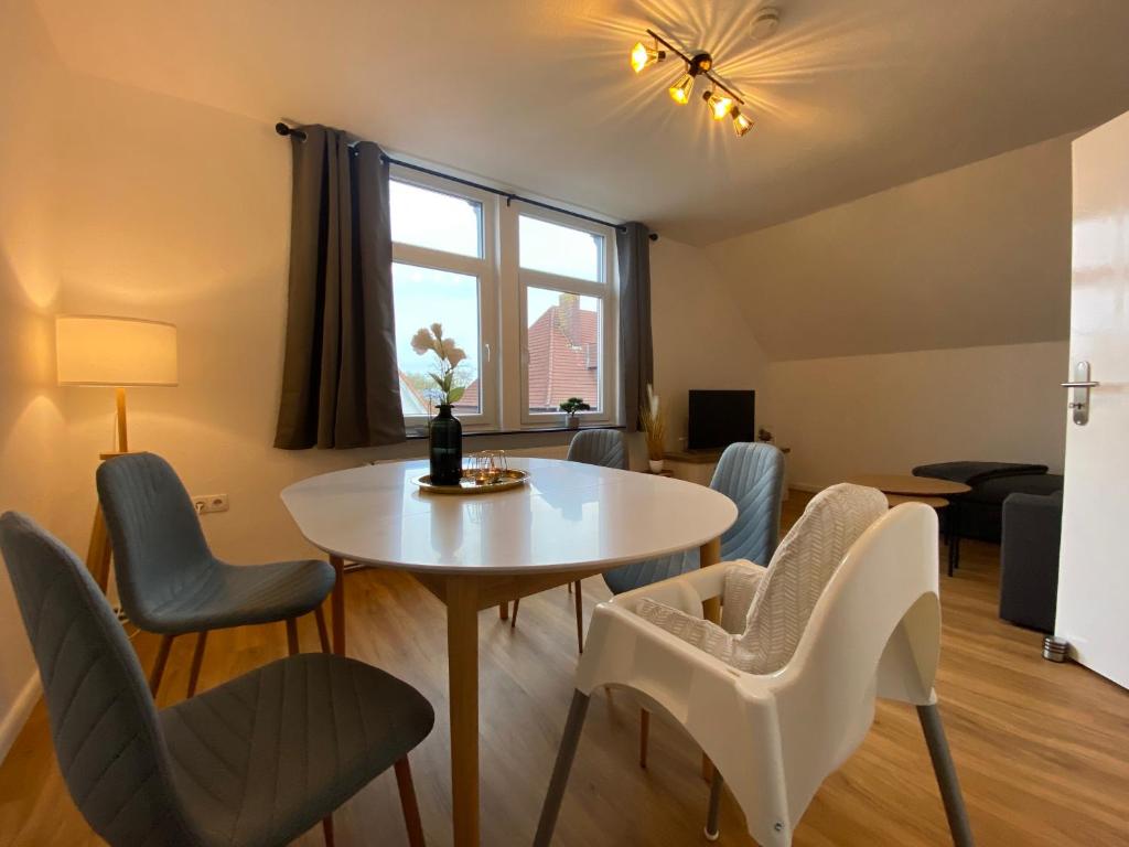 a living room with a table and chairs at Charmante Altbauwohnung an der Kesselschleuse 3 in Emden