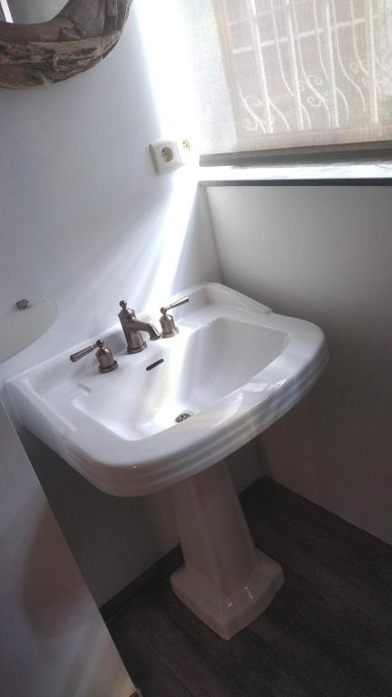 a white sink in a bathroom with a window at &#39;T boshuisje in Opglabbeek
