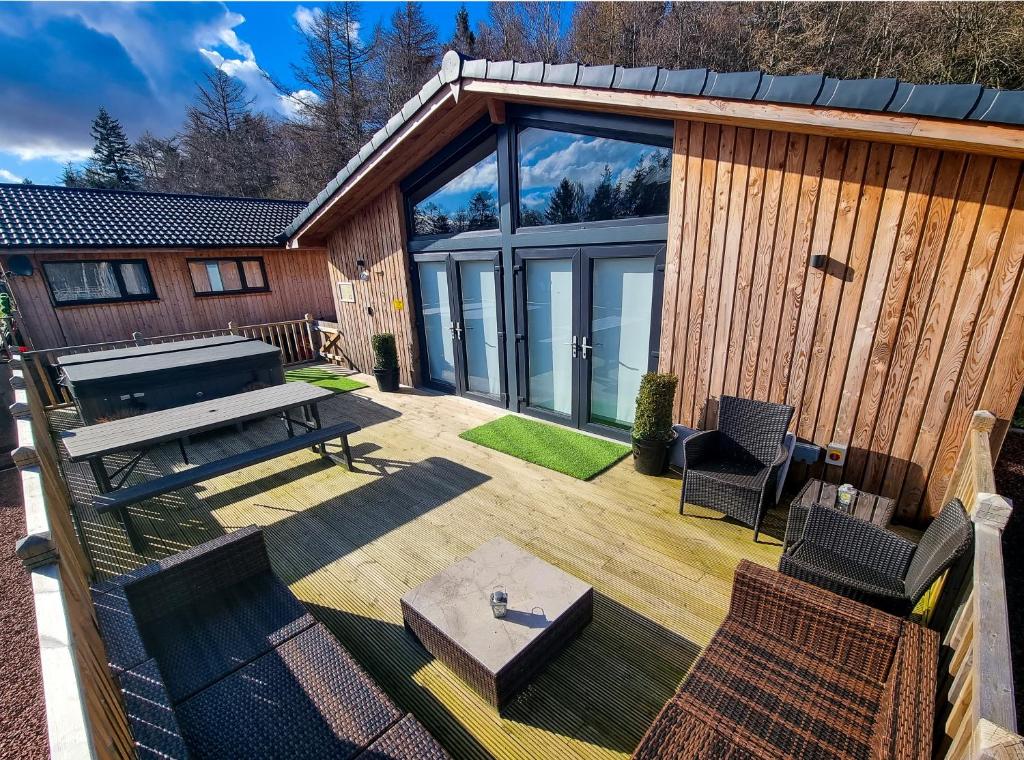 un patio al aire libre con mesa de picnic y sillas en Serenity Lodge Otterburn en Otterburn