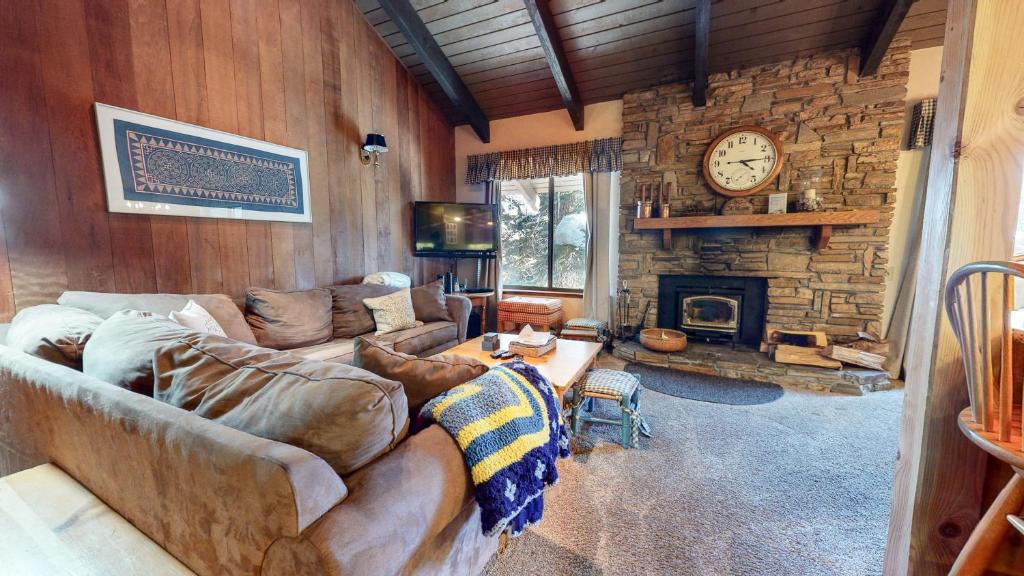 a living room with a couch and a stone wall at Discover 4 in Mammoth Lakes
