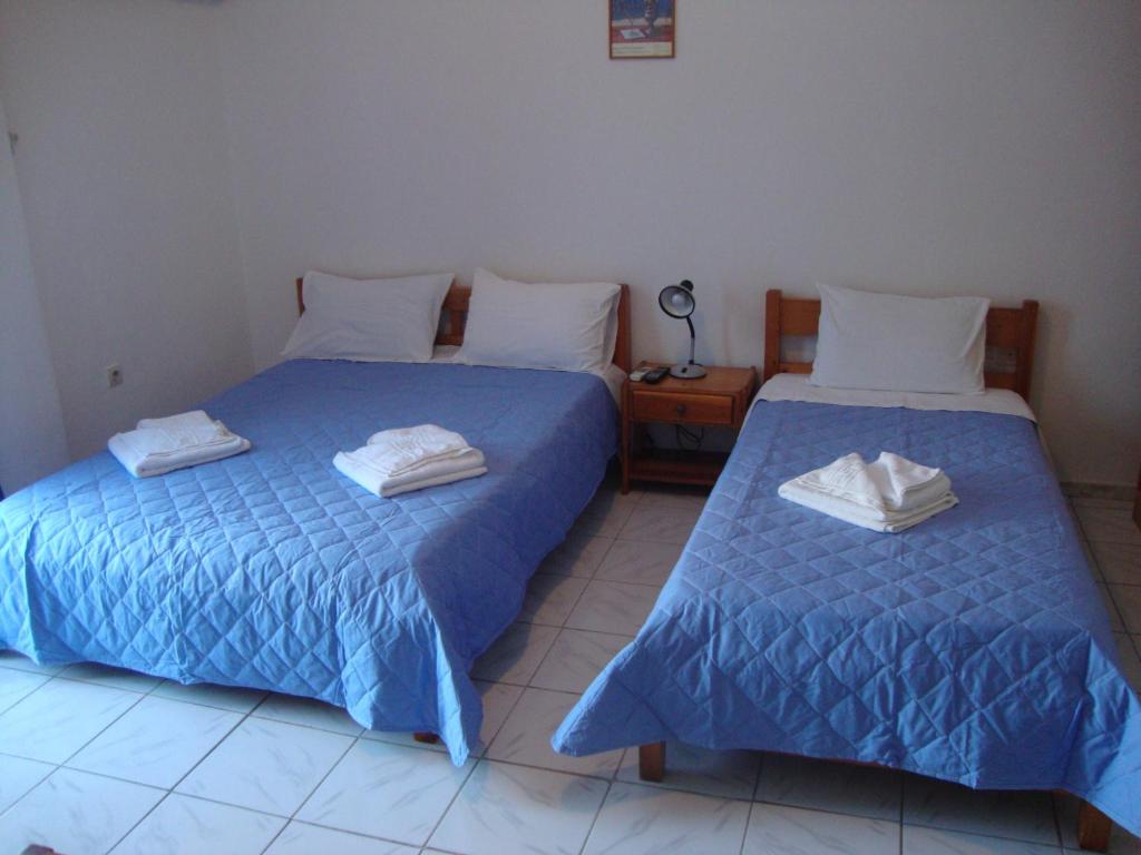 two beds sitting next to each other in a room at Esperides Hotel in Paralia Agias Foteinis