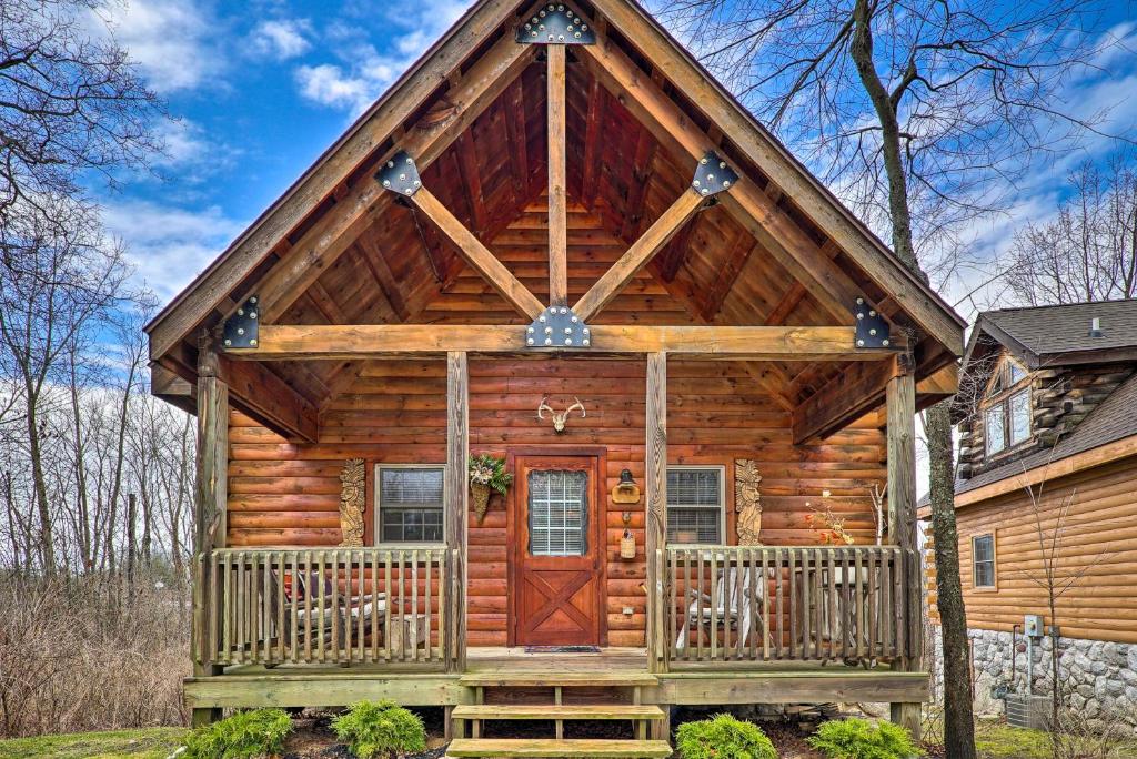drewniany domek z werandą i drewnianymi drzwiami w obiekcie Charming Log Cabin at Double JJ Ranch Resort! w mieście Rothbury