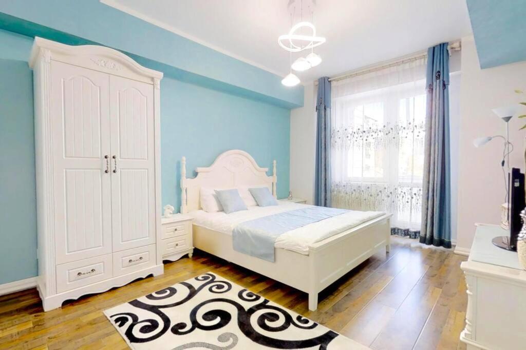 1 dormitorio con 1 cama blanca y paredes azules en 125m2 new apartment, 5 rooms with airport pickup, en Ulán Bator