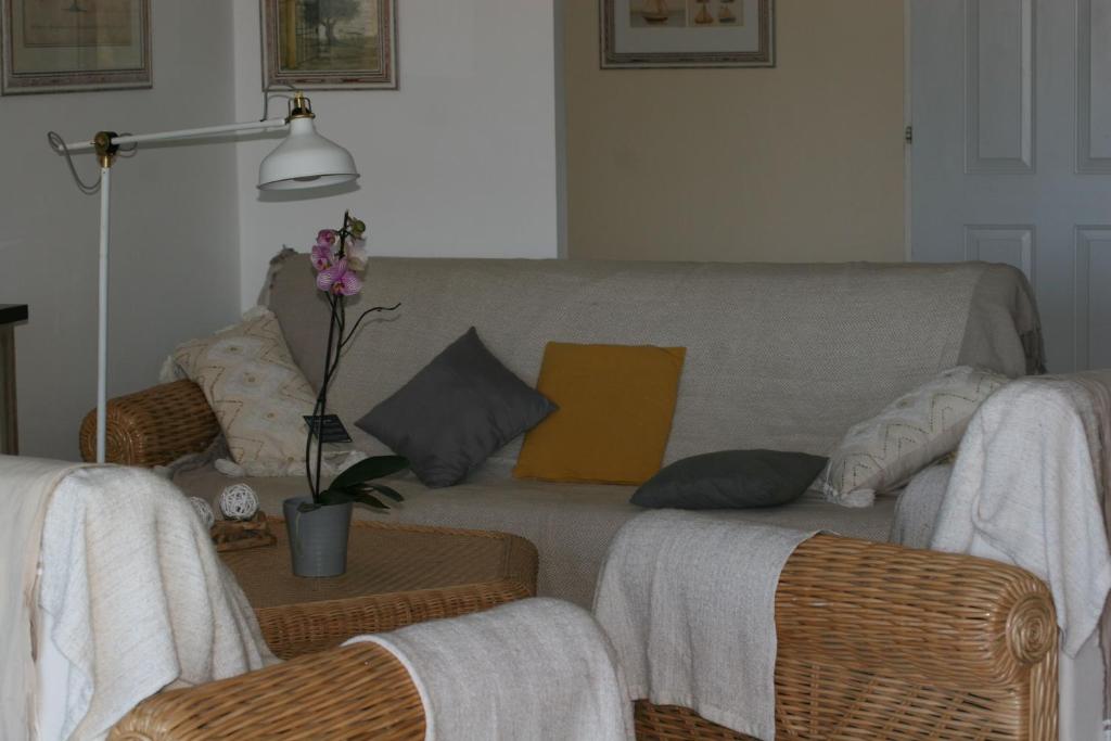 a living room with a couch and wicker chairs at Hotel Villa Maya in Saint-Tropez