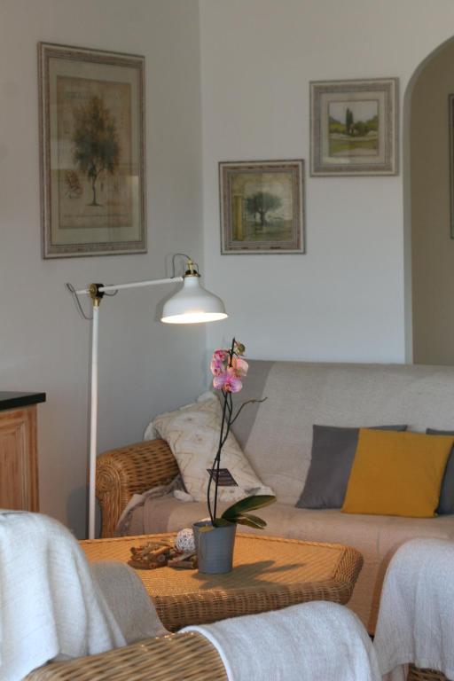 a living room with a couch and a table with a flower on it at Hotel Villa Maya in Saint-Tropez