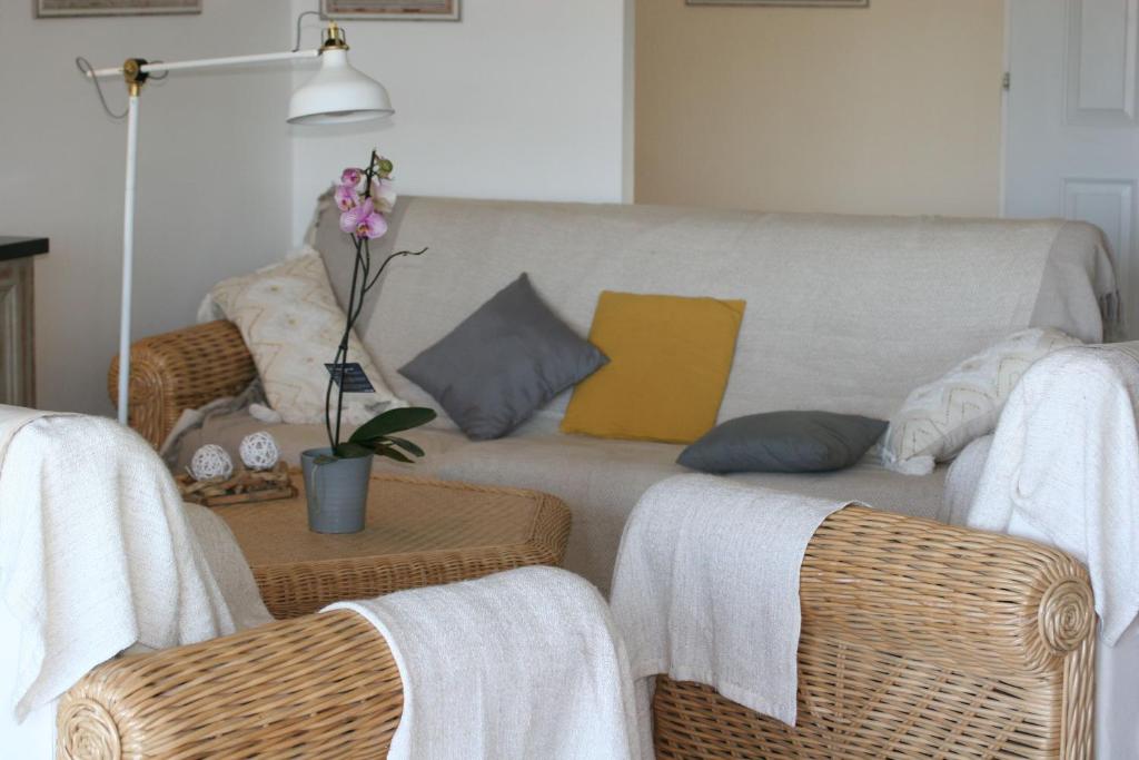 a living room with a couch and wicker chairs at Hotel Villa Maya in Saint-Tropez