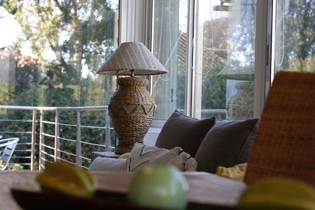 a lamp sitting on a couch in front of a window at Hotel Villa Maya in Saint-Tropez