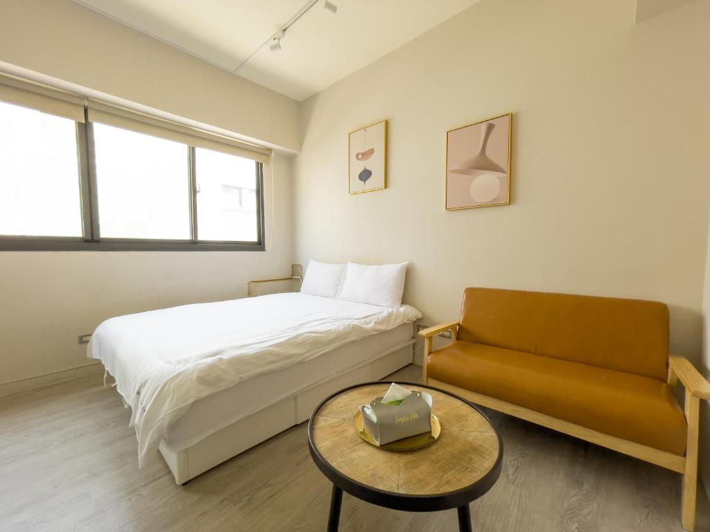 a bedroom with a bed and a couch and a table at meimo文旅 in Taichung