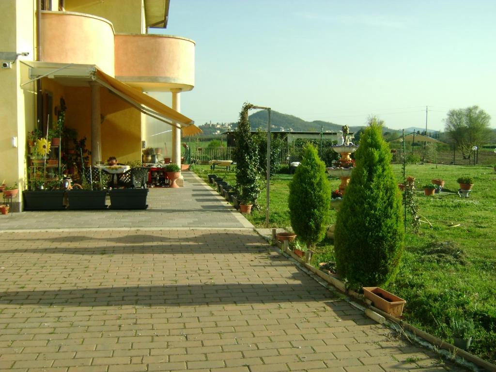 a walkway next to a building with bushes and trees at Casa Marblu via Cairoli, 47 Corciano in Corciano