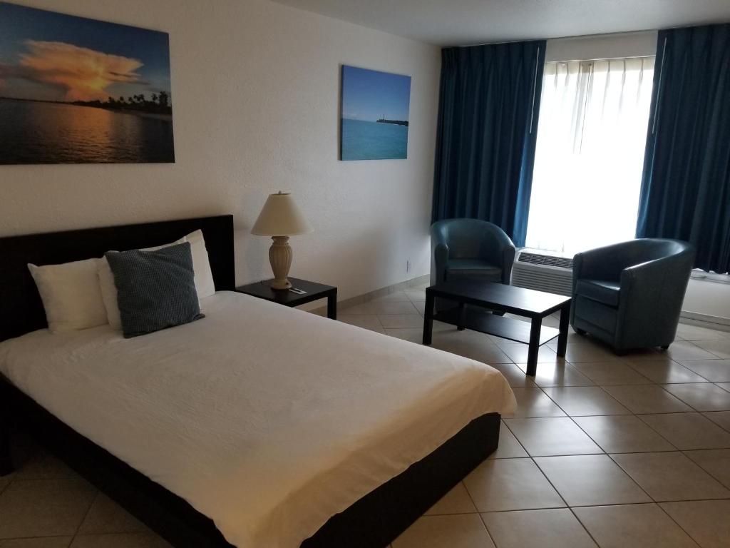 a hotel room with a large bed and a chair at Dolphin Key Resort - Cape Coral in Cape Coral