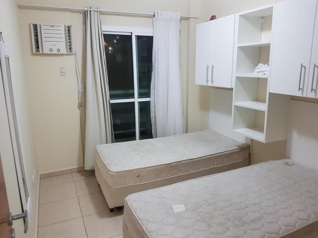 una piccola stanza con due letti e una finestra di Vila del mar prainha ad Arraial do Cabo